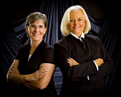 Photo fo Jeanne Finstein and Judi Hendrickson, both in black in black background